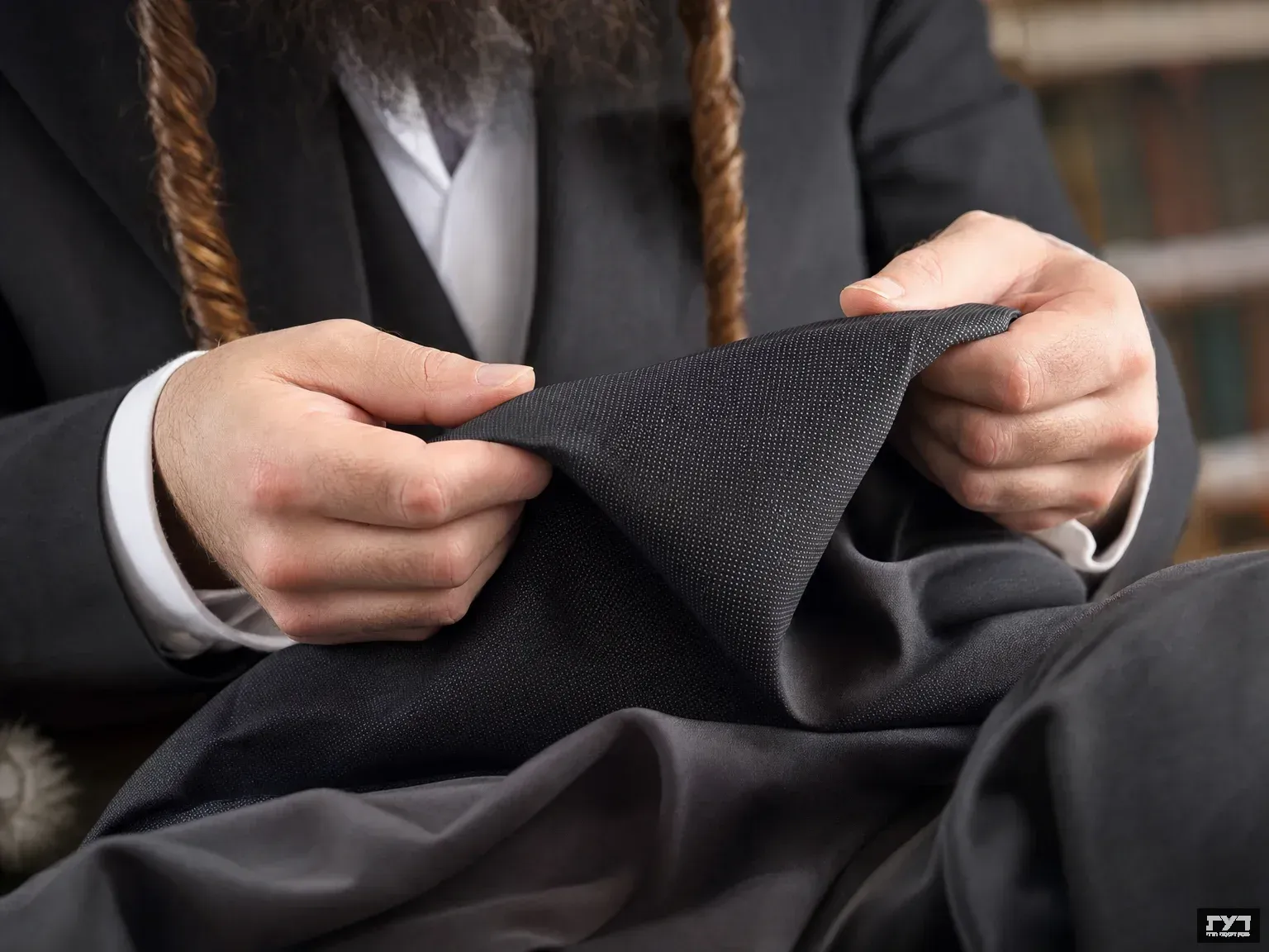 ידיים בוחנות מרקם בד חכם אדפטיבי, גבר חרדי בחליפה מסורתית